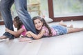 Low section of father dragging girls on hardwood floor