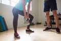 Low section of female athlete lifting kettlebells while standing by trainer