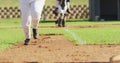 Low section of female baseball players playing on the field, hitter running for base