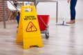 Cleaner Standing With Mop And Caution Wet Floor Sign Royalty Free Stock Photo