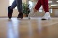 Low section of friends rehearsing dance on floor