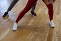 Low section of friends rehearsing dance on wooden floor