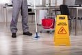 Cleaner Standing With Mop And Caution Wet Floor Sign Royalty Free Stock Photo