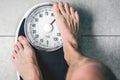 Low section of man standing on weight scale Royalty Free Stock Photo