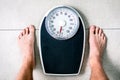 Low section of man standing on weight scale Royalty Free Stock Photo