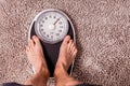 Low section of man standing on weight scale Royalty Free Stock Photo