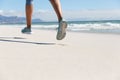 Low section of mixed race woman exercising on beach running