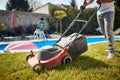 Low section shot of young man mowing grass by the pool, clean cut grass Royalty Free Stock Photo