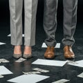 low section view of businesspeople standing on floor with documents and money,