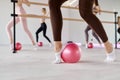 Low section view at row of women stretching feet using fitness ball