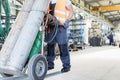 Low section of young manual worker moving gas cylinders in metal industry Royalty Free Stock Photo