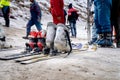 Low shot of sking boots on skis in snow showing crowd of people in winter wear playing in snow, sking, sliding, at snow