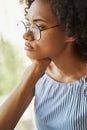 Low-spirited female in trendy circle eyeglasses staring into the distance