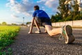 Low start for running, close leg view, teen boy runs along the stadium track, a soccer field with green grass - concept of sports Royalty Free Stock Photo