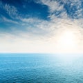 Low sun in white clouds over blue sea Royalty Free Stock Photo