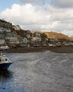 Low tide boats moored by Looe bridge on cloudy Spring day.