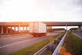 A low-tonnage commercial refrigerated van transports perishable products in the summer on a country road against the