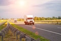 A low-tonnage commercial refrigerated van transports perishable products in the summer on a country road against the