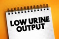 Low urine output text on notepad, medical concept background