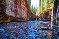Low view of shallow riverbed filled with colorful rocks in canyon by waterfall Royalty Free Stock Photo