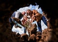 Low view of smiling family looking at hole for planting tree seedling.