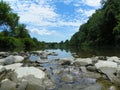 Low view of summer river walking on river rocks with blue sky Royalty Free Stock Photo