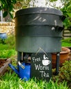 Low view of wormery compost bin in organic Australian garden with sign for Free Worm Tea, sustainable living and zero waste