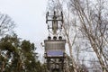 Low voltage transformer station standing on a concrete pole at the edge of the forest. Royalty Free Stock Photo