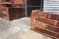 Low Wall Of Mixed Recycled Brick And Block Before A Locked Chain Link Entrance