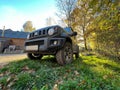 Low and wide angle shot on a small Suzuki Jimny Jeep in natural forested environment