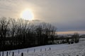 Winter sunset over snow covered fields with trees in the Flemish countryside Royalty Free Stock Photo