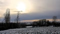Winter sunset over snow covered fields with trees in the Flemish countryside Royalty Free Stock Photo