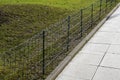 A low wire fence separates the walkway in the park from the lawn. It is a measure against the entry of people from dogs. Urine and Royalty Free Stock Photo