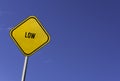 Low - yellow sign with blue sky background