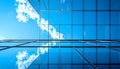 Corner of modern blue glass office building with grid pattern reflecting white clouds and blue sky Royalty Free Stock Photo