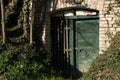 green wooden door of a wine cellar built from bricks