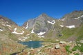 The lower Blue Lake Ibon Azul, among barren rocky mountains with snow and a blue sky in a sunny autumn, in Panticosa, Aragon