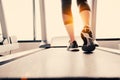 Lower body at legs part of Fitness girl running on running machine or treadmill in fitness gym with sun ray. Warm tone. Healthy Royalty Free Stock Photo