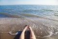 Lower half of the girl body lying on the beach by the sea Royalty Free Stock Photo