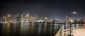 Manhattan, its skyline and the Brooklyn Bridge at night, seen from Brooklyn side of the Hudson River Royalty Free Stock Photo