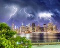 Lower Manhattan night skyline with storm approaching. East River Downtown skyscrapers lights reflections, New York City - USA Royalty Free Stock Photo