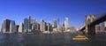 Lower Manhattan skyline, Eastern River and Brooklyn Bridge with a yellow water taxi boat on the foreground, New York City Royalty Free Stock Photo