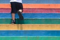 Lower part of a boy in casual shoe walking up outdoor colorful stair,children lifestyle successful concept Royalty Free Stock Photo