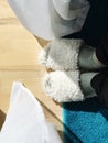 the lower part of the legs in white slippers on a blue carpet on the floor Royalty Free Stock Photo