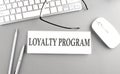 LOYALTY PROGRAM text on paper with keyboard on grey background Royalty Free Stock Photo