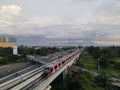 LRT , Monorail movement on track moving fast taken at station Cibubur. with background of traffic ,mountain and sky. Jakarta,