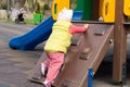 Lttle girl is played in the playground. Child in warm clothes walks Royalty Free Stock Photo