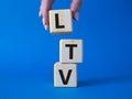 LTV - Life Time Value symbol. Concept word LTV on wooden cubes. Businessman hand. Beautiful blue background. Business and LTV Royalty Free Stock Photo