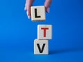 LTV - Life Time Value symbol. Concept word LTV on wooden cubes. Businessman hand. Beautiful blue background. Business and LTV Royalty Free Stock Photo