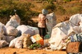 Woman picking through trash piled up at a local dump site